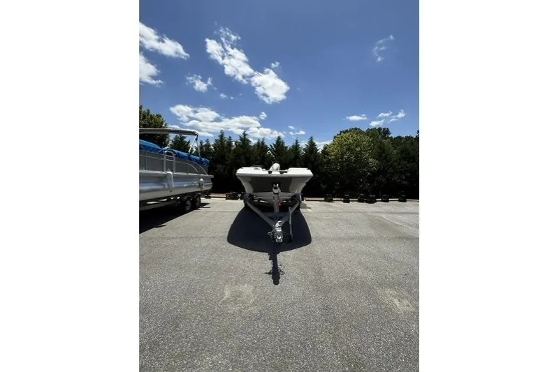 Slide: The Image of 2021 Hurricane SunDeck Sport 205 OB boat on trailer under clear blue sky. - 1