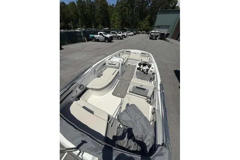 Slide: The Image of 2021 Hurricane SunDeck Sport 205 OB boat with spacious seating, parked outdoors. - 8