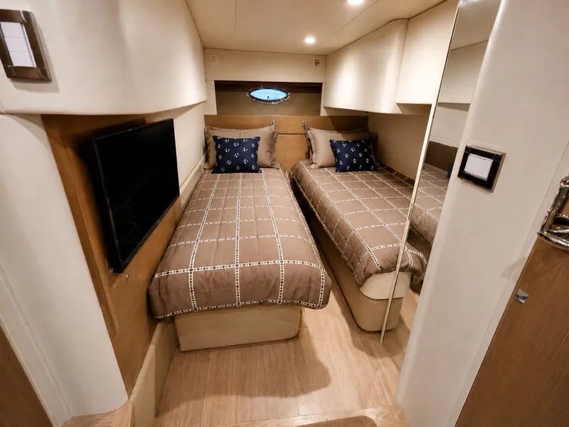 Slide: The Image of Two single beds in an elegant cabin with wood flooring and a small window. - 7