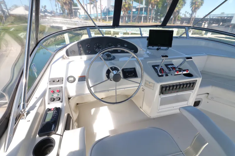Slide: The Image of 1999 Bayliner 3988 Command Bridge Motoryacht helm with steering wheel and control panel. - 13