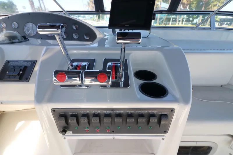 Slide: The Image of 1999 Bayliner 3988 Command Bridge Motoryacht helm controls and dashboard with switches. - 15