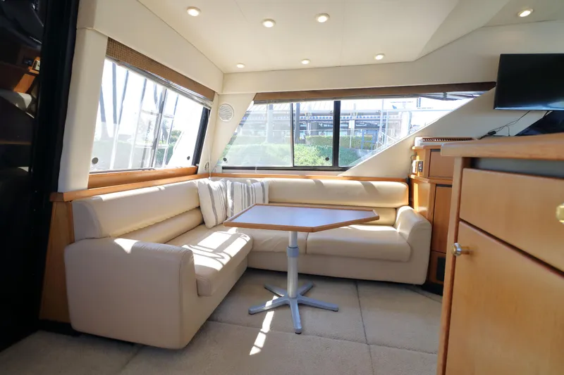Slide: The Image of Interior of 1999 Bayliner 3988 Command Bridge Motoryacht with beige seating and wooden accents. - 22