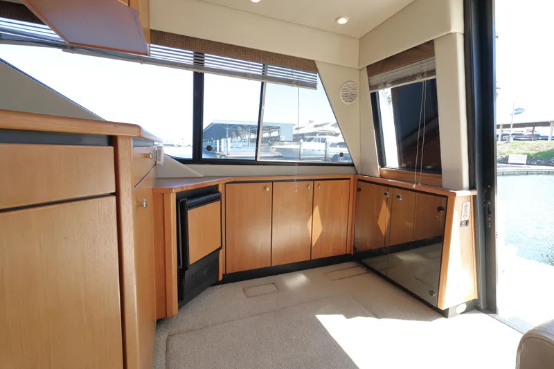 Slide: The Image of Interior of 1999 Bayliner 3988 Command Bridge Motoryacht with wood cabinetry and large windows. - 23