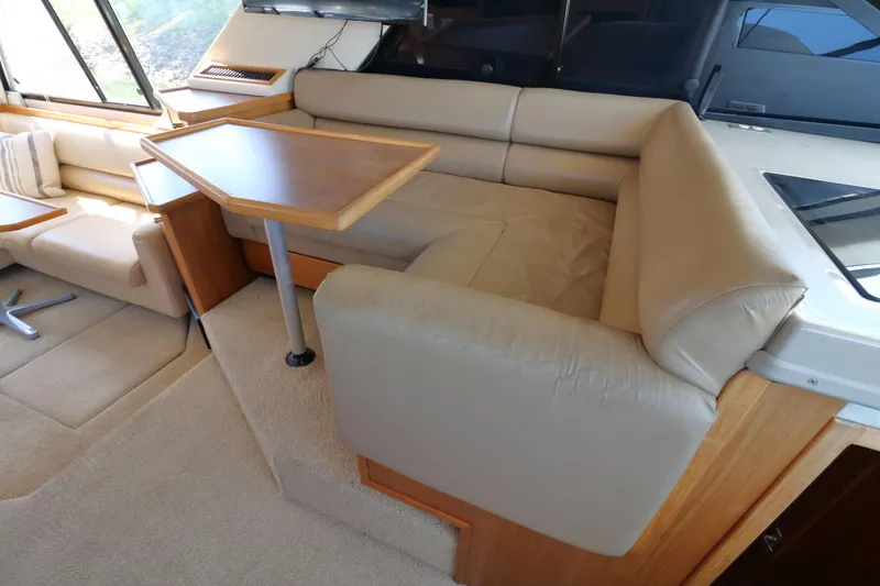 Slide: The Image of Interior of 1999 Bayliner 3988 Command Bridge Motoryacht with beige seating and wooden table. - 27