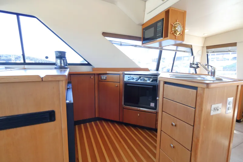 Slide: The Image of Interior of 1999 Bayliner 3988 Command Bridge Motoryacht kitchen with wood cabinetry and appliances. - 28