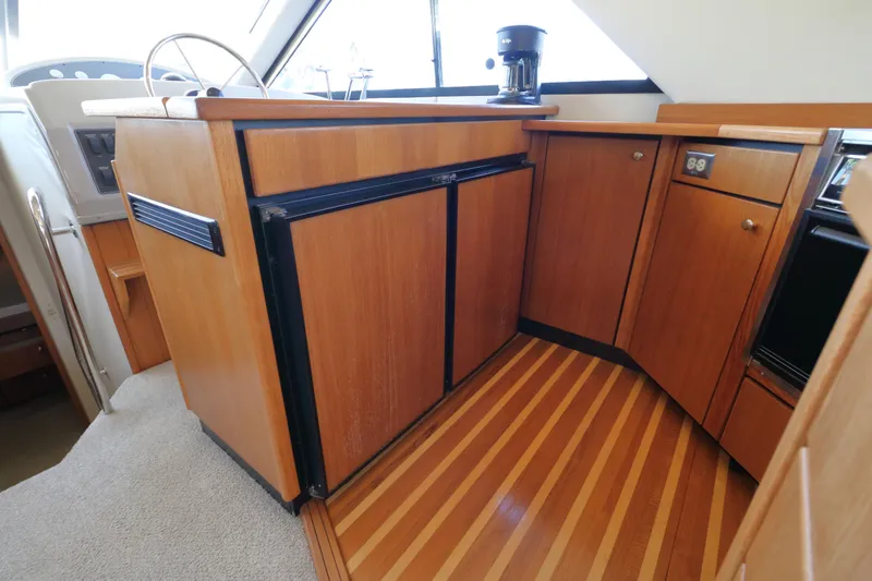 Slide: The Image of 1999 Bayliner 3988 Command Bridge Motoryacht interior with wood cabinetry and striped flooring. - 29