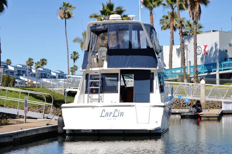 Slide: The Image of 1999 Bayliner 3988 Command Bridge Motoryacht docked at marina with palm trees. - 3