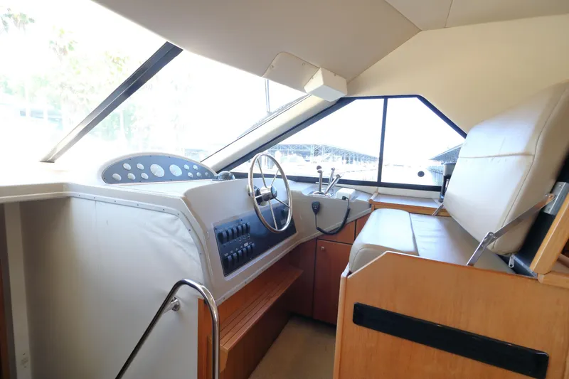Slide: The Image of 1999 Bayliner 3988 Command Bridge Motoryacht helm with steering wheel and control panel. - 32