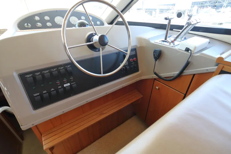 Slide: The Image of 1999 Bayliner 3988 Command Bridge Motoryacht helm with steering wheel and control panel. - 34