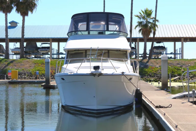 Slide: The Image of 1999 Bayliner 3988 Command Bridge Motoryacht docked at marina, front view. - 4