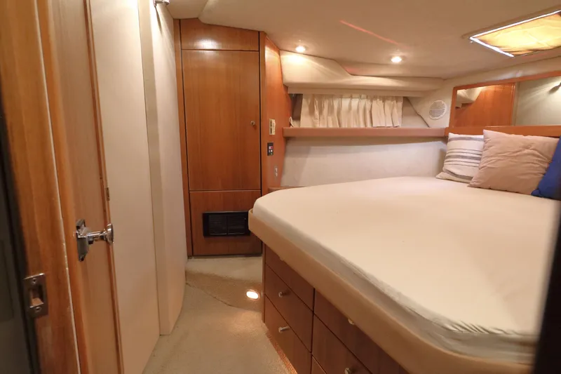 Slide: The Image of 1999 Bayliner 3988 Command Bridge Motoryacht cabin with cozy bed and wooden cabinetry. - 40