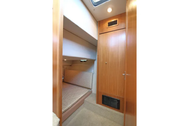 Slide: The Image of 1999 Bayliner 3988 Command Bridge Motoryacht interior cabin with wood paneling and cozy bed. - 46