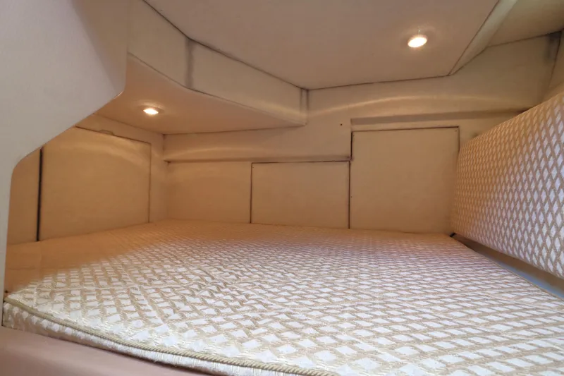Slide: The Image of 1999 Bayliner 3988 Command Bridge Motoryacht cabin interior with cozy bedding and soft lighting. - 48