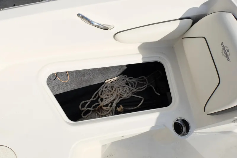 Slide: The Image of Storage compartment on a 2020 Stingray 191 DC boat with coiled rope inside. - 12