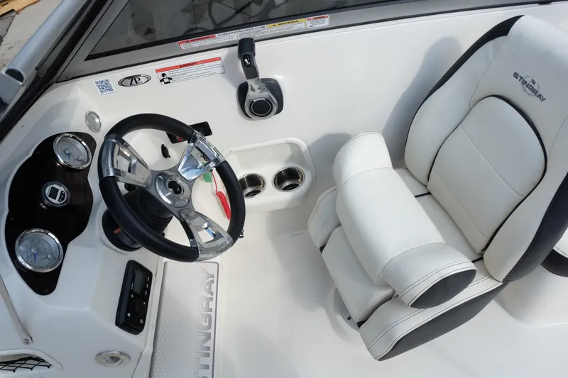 Slide: The Image of 2020 Stingray 191 DC boat interior with steering wheel and white captain's seat. - 14