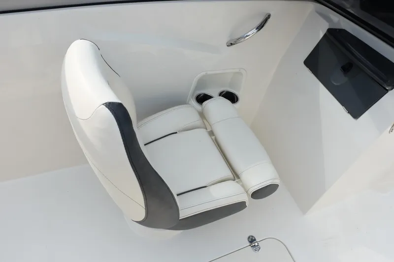 Slide: The Image of White leather boat seat in a 2020 Stingray 191 DC, featuring cup holders and armrests. - 17
