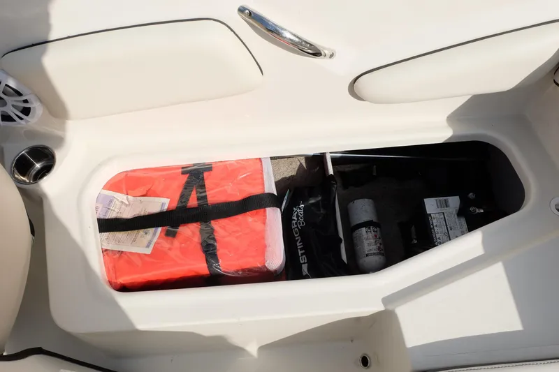 Slide: The Image of Storage compartment in a 2020 Stingray 191 DC boat with safety equipment. - 21