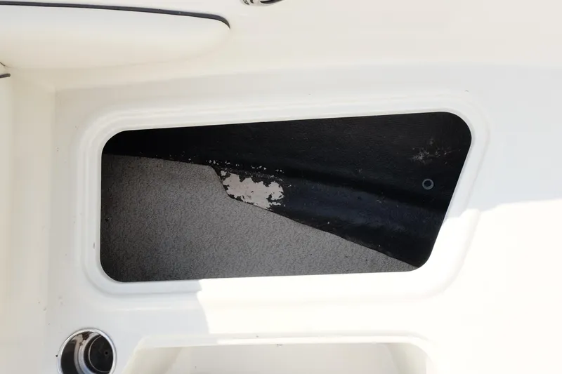 Slide: The Image of Storage compartment in a 2020 Stingray 191 DC boat, featuring a white and black interior. - 7