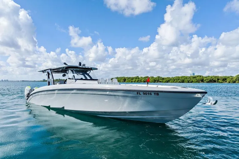 Slide: The Image of 2022 Midnight Express 43' Solstice boat on calm water under a cloudy sky. - 19