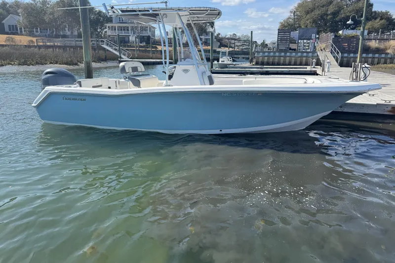 The Image of 2017 Tidewater 220 CC Adventure boat docked in calm waters, clear sky background. - 1