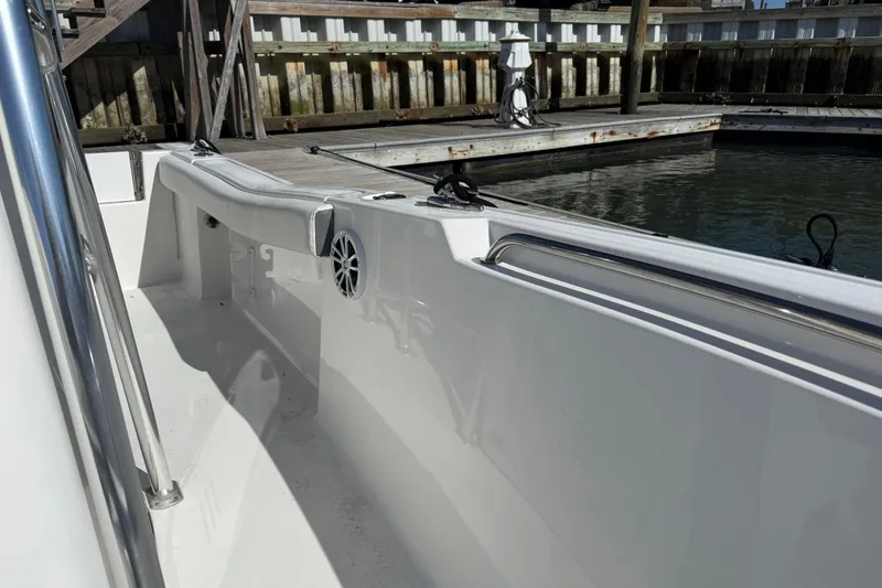 Slide: The Image of 2017 Tidewater 220 CC Adventure boat interior at dock, featuring sleek white design. - 16