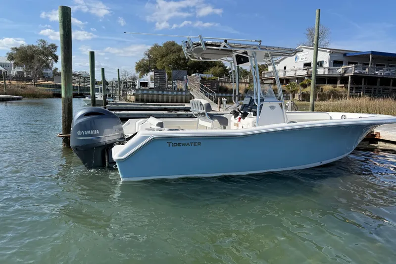 Slide: The Image of 2017 Tidewater 220 CC Adventure boat docked with Yamaha engine, clear sky background. - 3