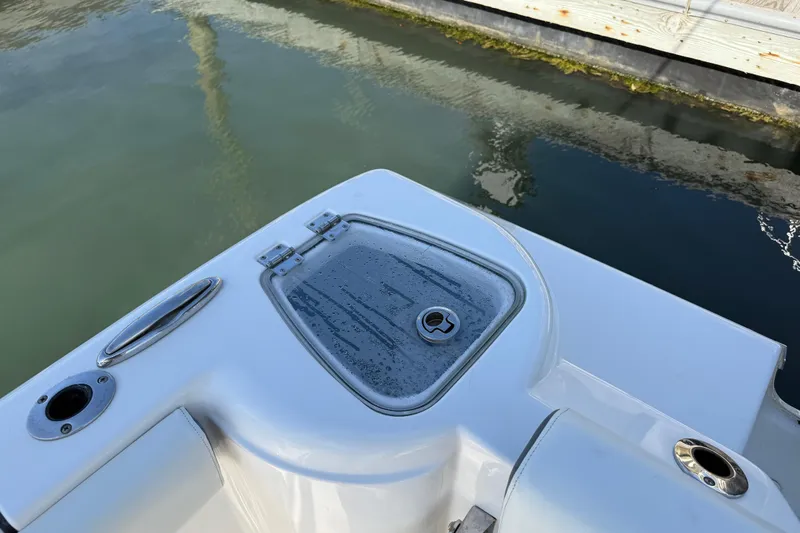 Slide: The Image of 2017 Tidewater 220 CC Adventure boat detail near dock, showing hatch and water surface. - 34