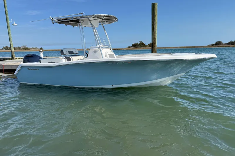 Slide: The Image of 2017 Tidewater 220 CC Adventure boat docked on calm water under clear blue sky. - 5