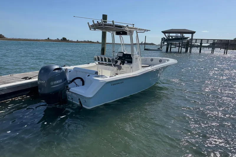 Slide: The Image of 2017 Tidewater 220 CC Adventure boat docked on calm water. - 8