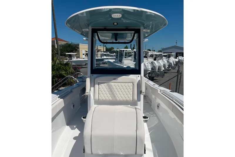 Slide: The Image of 2026 Sea Hunt Ultra 275 Coffin Box boat interior with seating and console, displayed outdoors. - 12