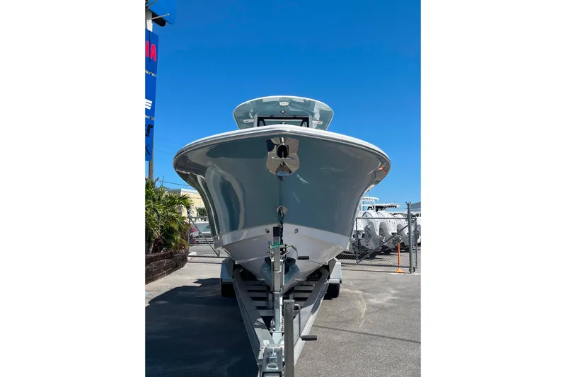 Slide: The Image of 2026 Sea Hunt Ultra 275 Coffin Box boat on trailer under clear blue sky. - 2