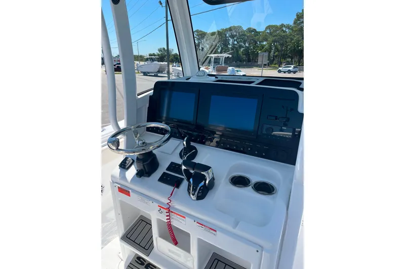 Slide: The Image of 2026 Sea Hunt Ultra 275 Coffin Box boat dashboard with steering wheel and dual screens. - 9