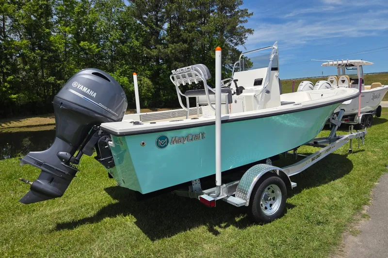 Slide: The Image of 2026 May-Craft 182 Center Console boat with Yamaha engine on trailer, parked on grass. - 2