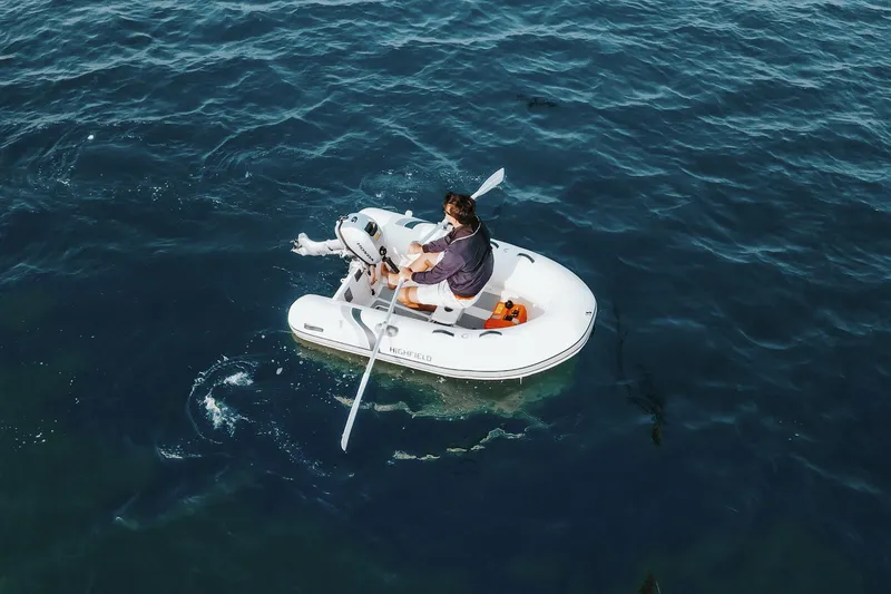 Slide: The Image of Man rowing a 2026 Highfield Ultralite 240 inflatable boat on open water. - 4