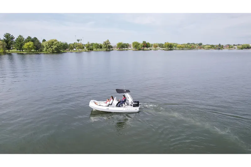 Slide: The Image of 2026 Highfield Sport 520 boat cruising on a serene lake with lush green shoreline. - 4