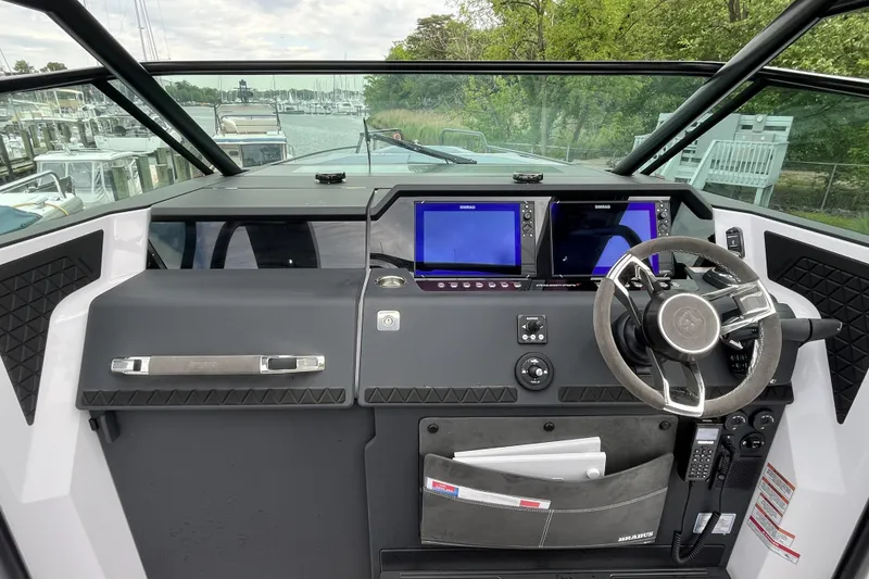 Slide: The Image of 2025 Axopar 37 Sun-Top boat dashboard with modern navigation screens and steering wheel. - 12