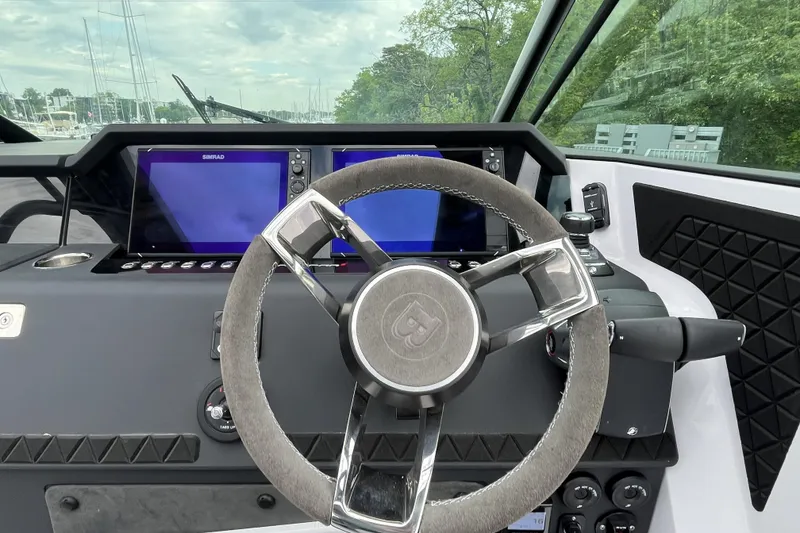 Slide: The Image of Steering wheel and dashboard of 2025 Axopar 37 Sun-Top boat with modern controls. - 14