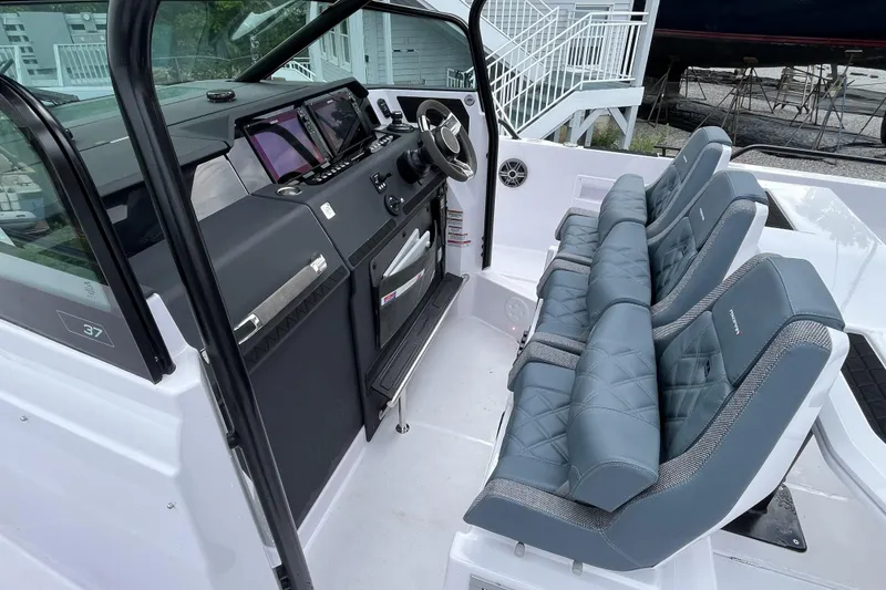 Slide: The Image of 2025 Axopar 37 Sun-Top boat interior with modern dashboard and cushioned seating. - 17