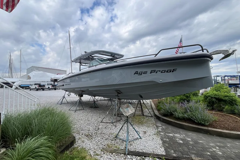 Slide: The Image of 2025 Axopar 37 Sun-Top boat displayed on stands in a marina setting. - 24