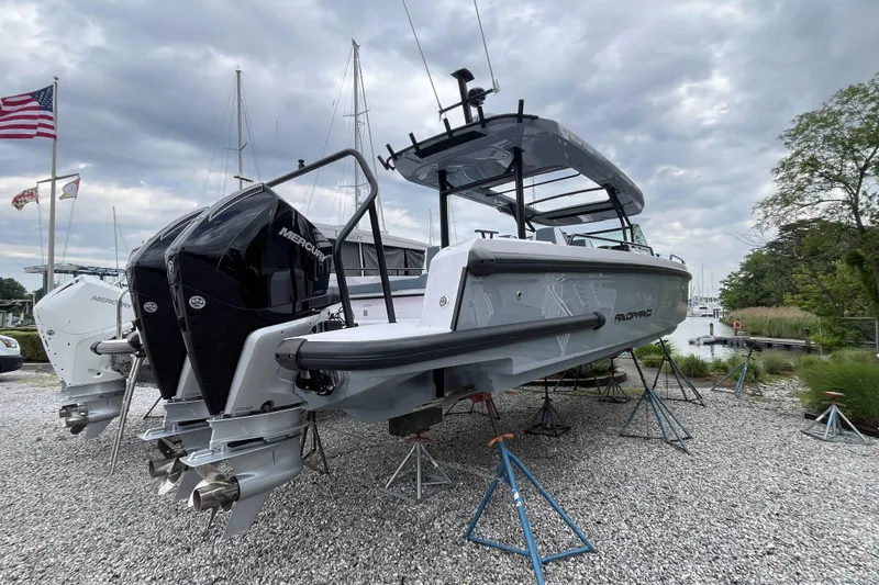 Slide: The Image of 2025 Axopar 37 Sun-Top boat with dual Mercury engines on display outdoors. - 25