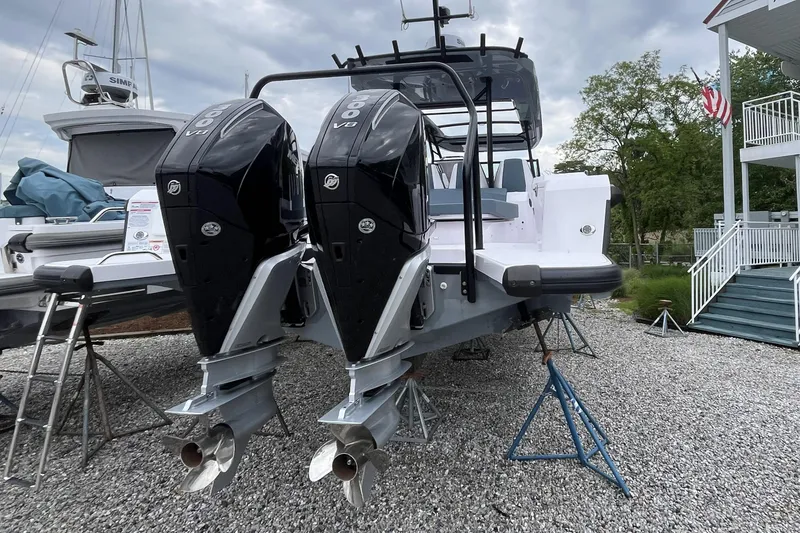 Slide: The Image of 2025 Axopar 37 Sun-Top with dual outboard engines on display, parked on gravel. - 26