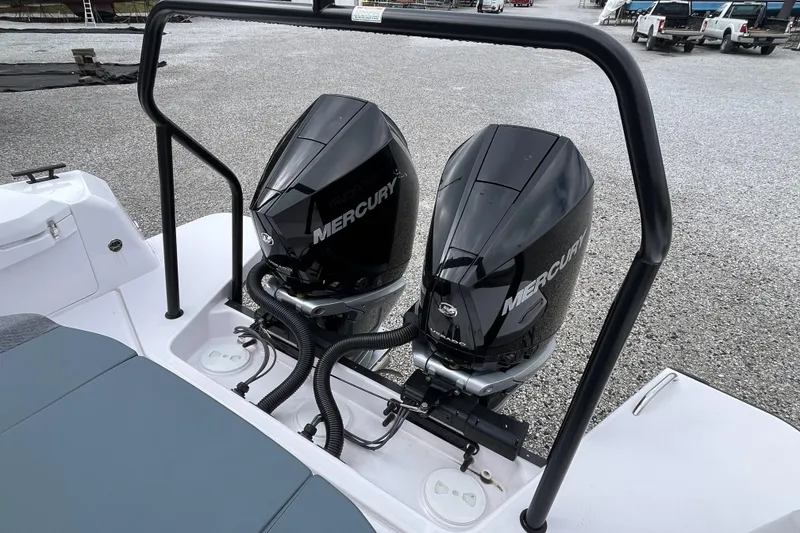 Slide: The Image of 2025 Axopar 37 Sun-Top with dual Mercury outboard engines, parked on gravel. - 28