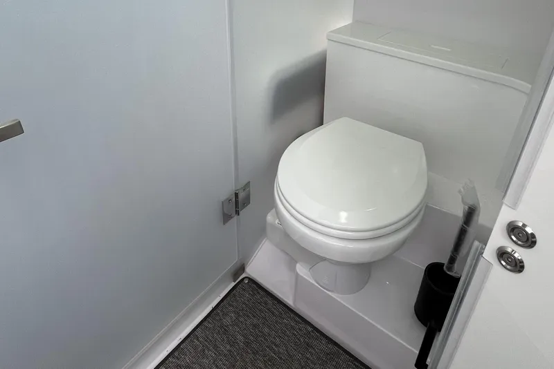 Slide: The Image of Modern bathroom interior on 2025 Axopar 37 Sun-Top boat, featuring a sleek white toilet. - 34
