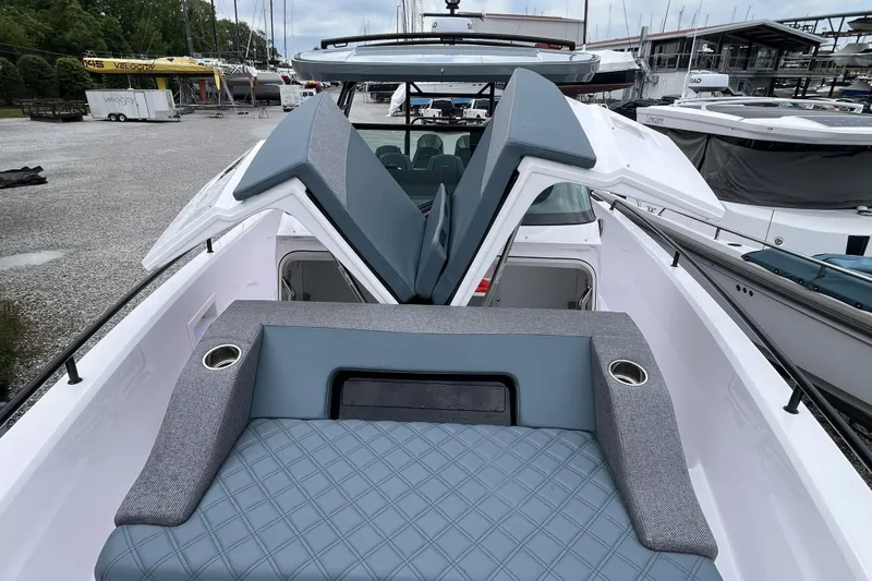 Slide: The Image of 2025 Axopar 37 Sun-Top boat interior with cushioned seating and open storage compartments. - 38