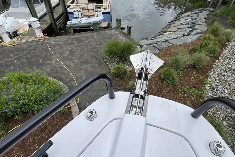 Slide: The Image of Bow view of 2025 Axopar 37 Sun-Top at dockside with lush greenery. - 41
