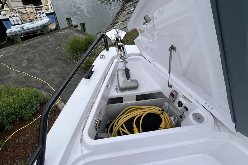 Slide: The Image of 2025 Axopar 37 Sun-Top boat storage compartment with anchor and yellow cable. - 42