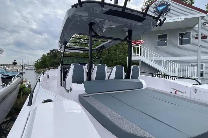 Slide: The Image of 2025 Axopar 37 Sun-Top boat with sleek design, docked near a marina building. - 45