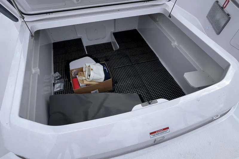 Slide: The Image of Storage compartment of 2025 Axopar 37 Sun-Top boat with various items inside. - 46