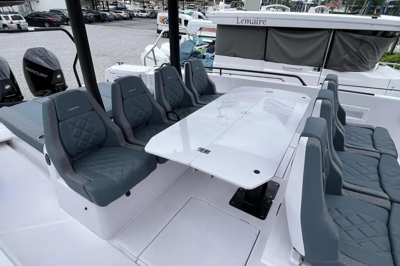 Slide: The Image of 2025 Axopar 37 Sun-Top boat with spacious seating and table, featuring Mercury engines. - 52