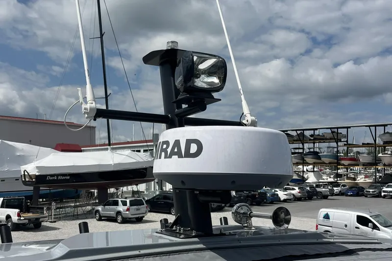 Slide: The Image of Radar equipment on 2025 Axopar 37 Sun-Top boat, docked at a marina under cloudy skies. - 65